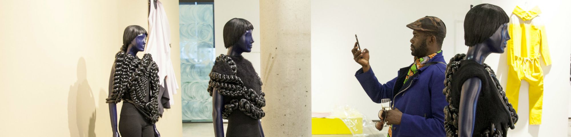 Man taking a photo of a mannequin in a gallery