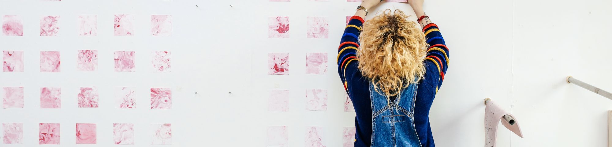 Student creating art on a white wall