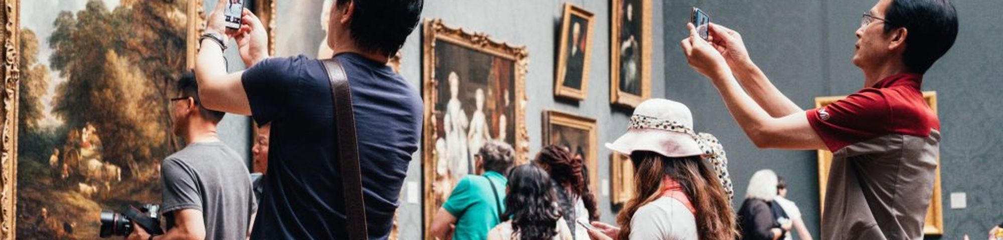 people photographing a painting in a museum