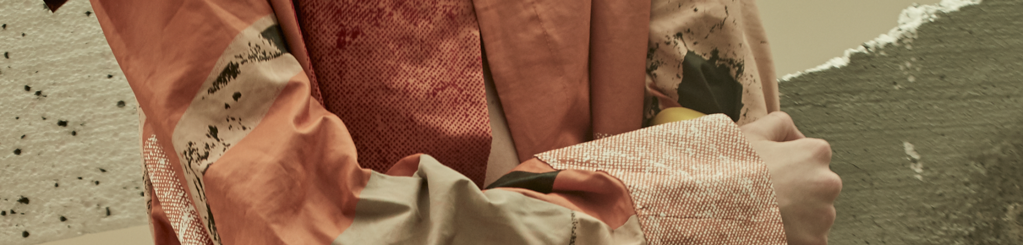 Close-up of rust coloured textured garment on a folded arm