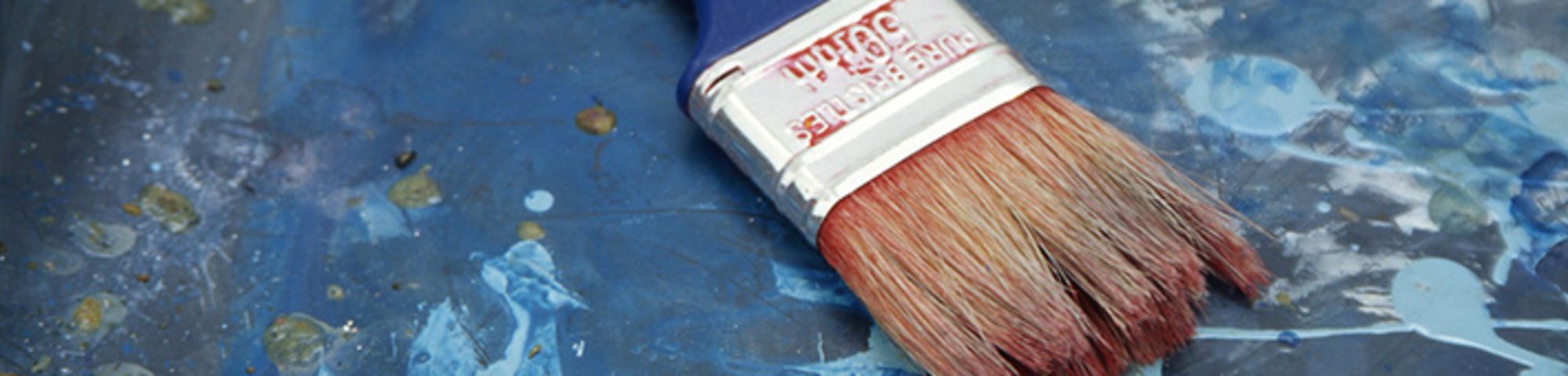 Paint brush laid on top of painting