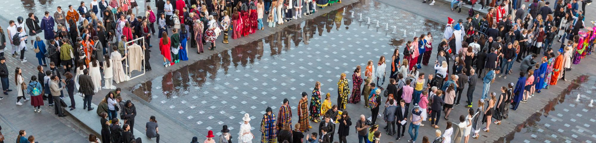 A large group of people standing by the fountains at Granary Square in London