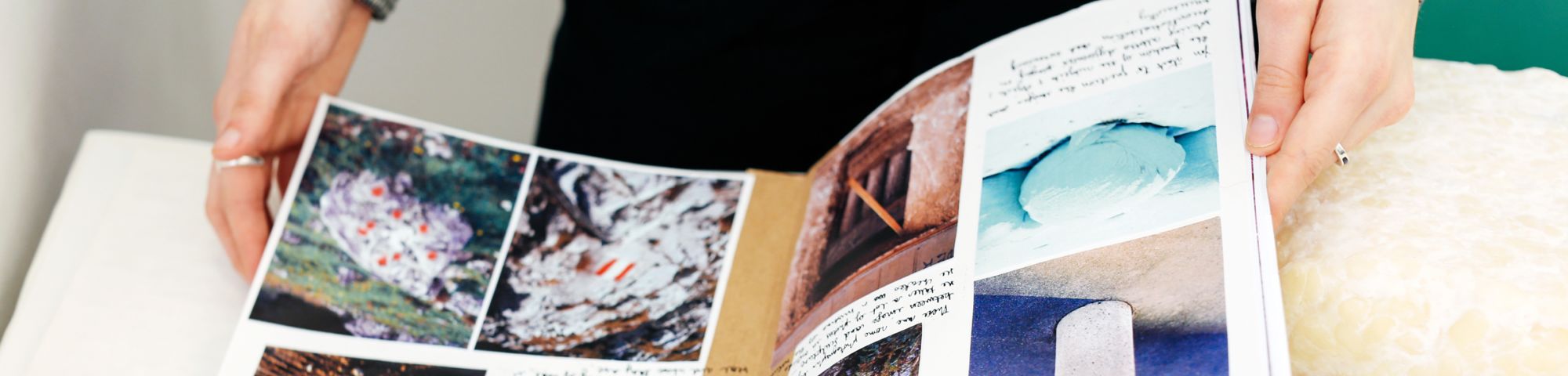 Hands leafing through a portfolio with photos inside