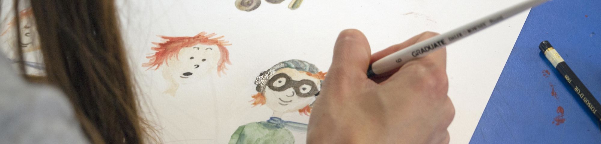 Student working on a character design in watercolour