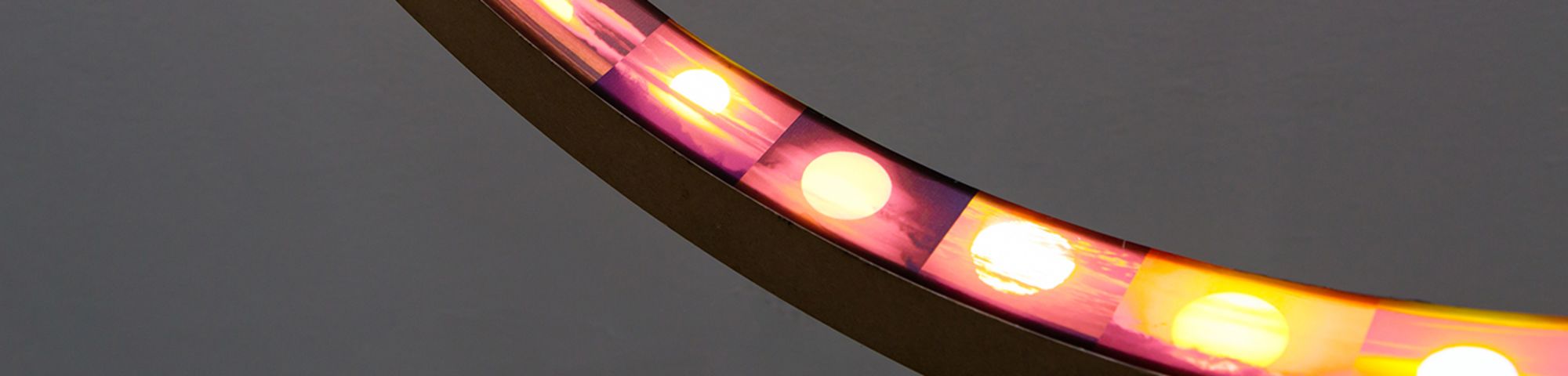 A series of sunrises are displayed on the inside of a curved circular object.