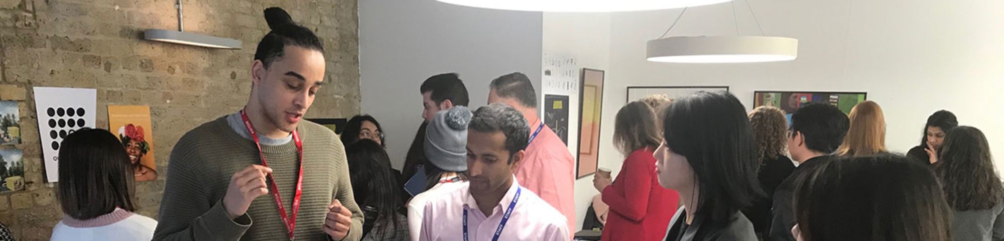 A group of students and audience members peer at project assets.