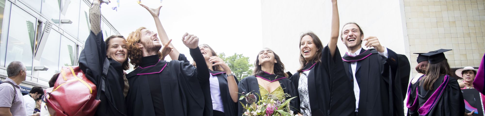 Student throwing mortarboards into the air