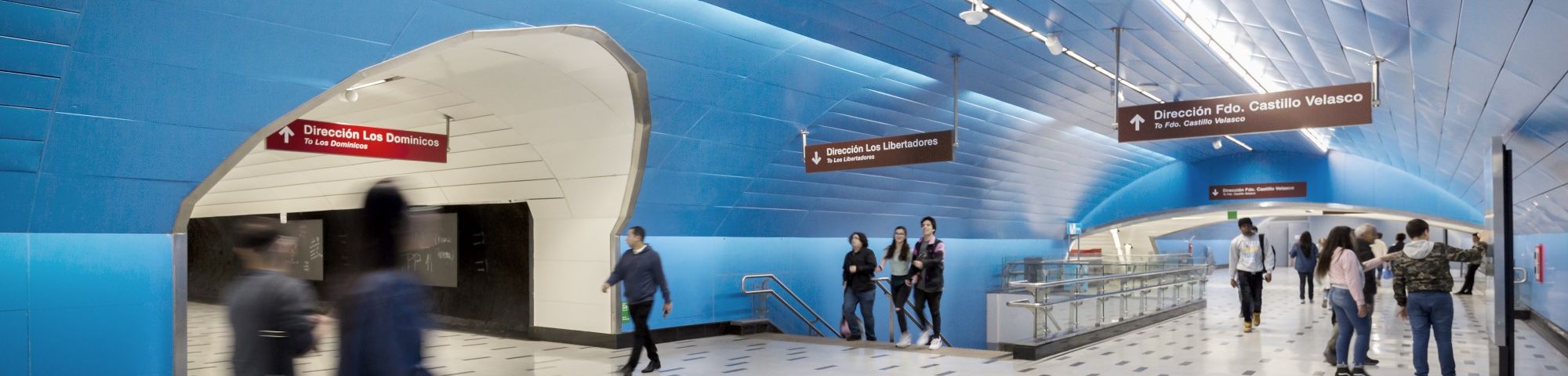 people walking within blue walkway tunnel