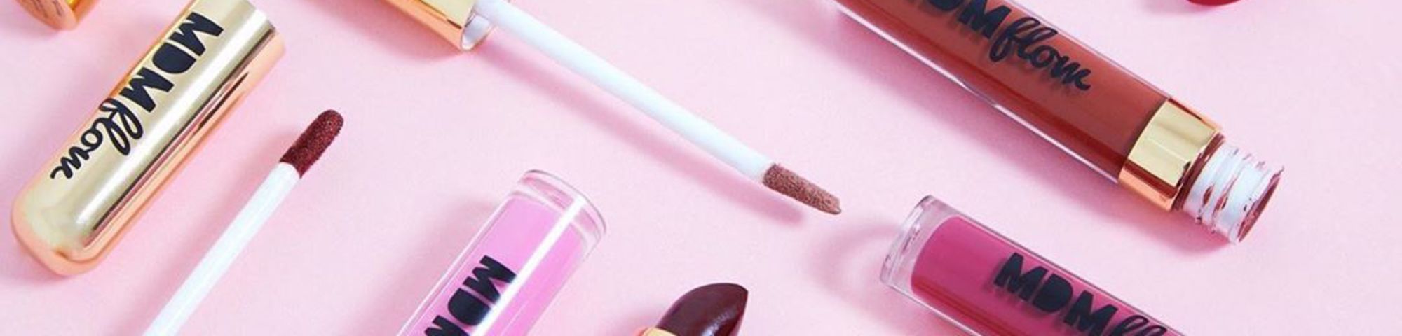 Combination of different colourful lipsticks on pink background