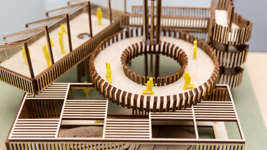 A wooden building miniature with yellow figurines