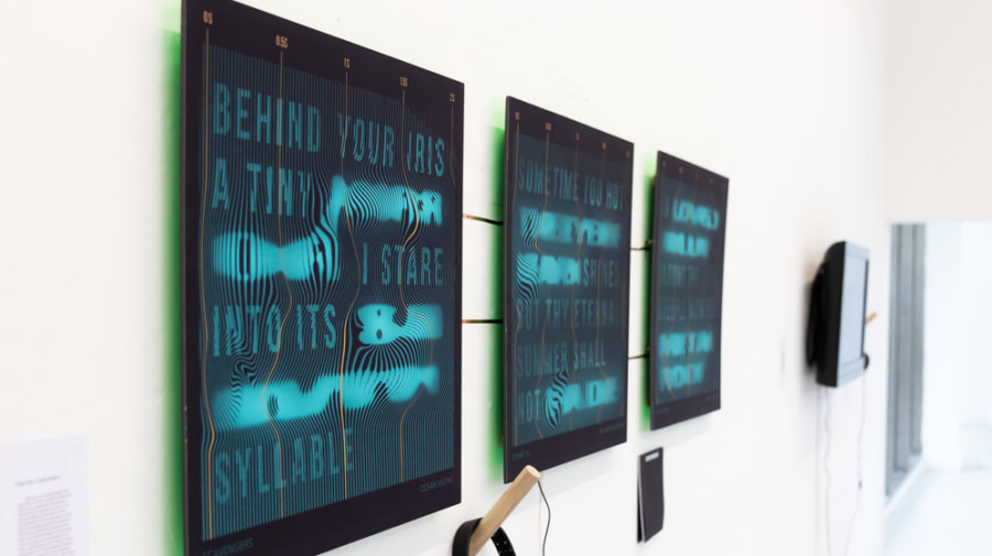 Three digital screens hung horizontal on a wall.