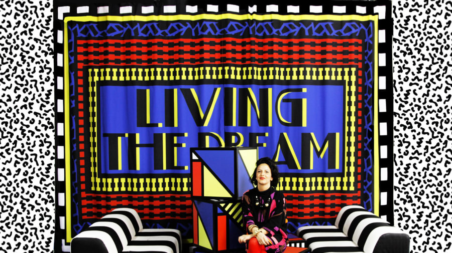lady sitting on a graphic coloured sofa with black and white backdrop
