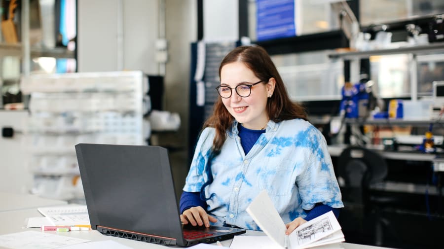 Image of Lucie Brosson smiling whilst looking at her laptop