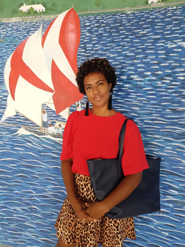 A women in a red top and leopard print skirt poses against a blue background