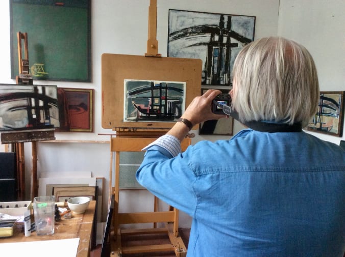A picture of Andrew taking a photo of his work, in his studio
