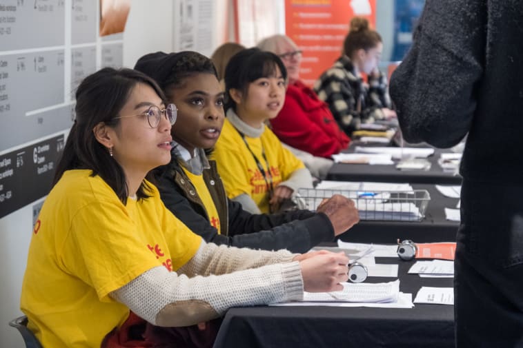 Three students at a welcome desk