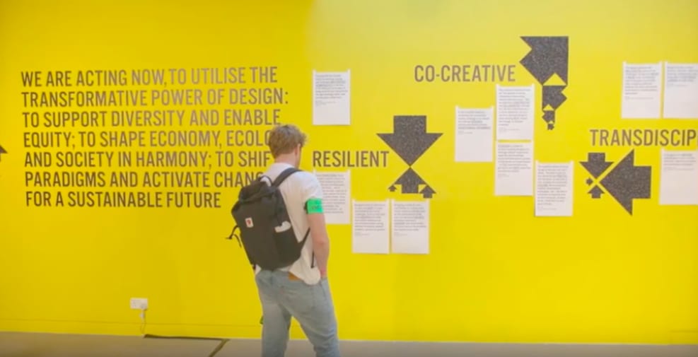 Visitor of London College of Communication's Design School's exhibition and events programme EMERGENCE, viewing a section of the exhibition detailing the principles of the Design School on sustainability.