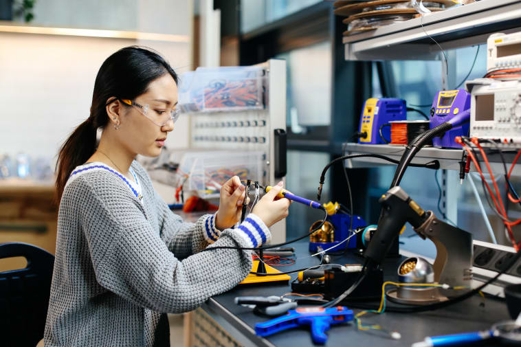 Anna Tsuda working in the studio wearing protective goggles.