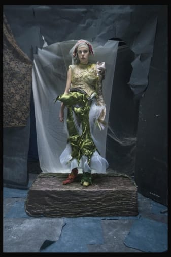 Women wearing green outfit, standing on pedestal
