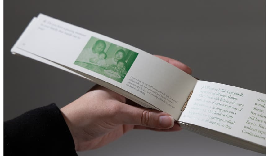 A photograph of someone holding a small, bound book filled with green images.