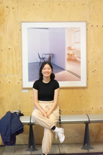 Girl sitting in front of a painting 