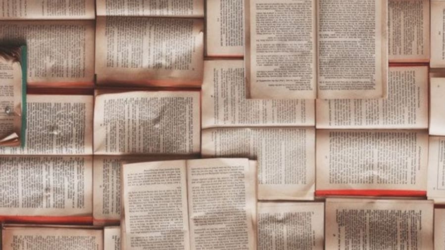 books opened flat and piled together