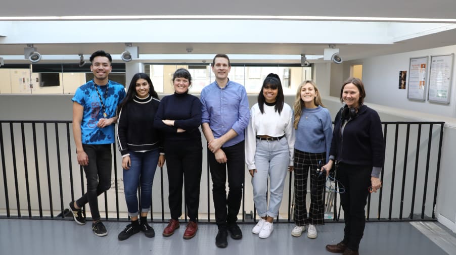 Posed group photo of Bruce Daisley with BBC producer and LCC students smiling at camera