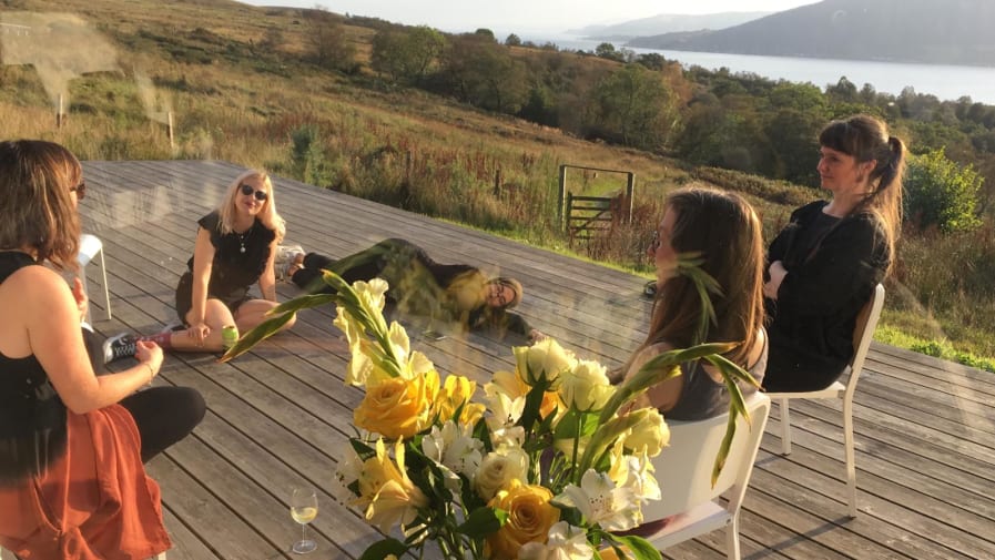 A group looking at plants and grass outdoors in the sunshine