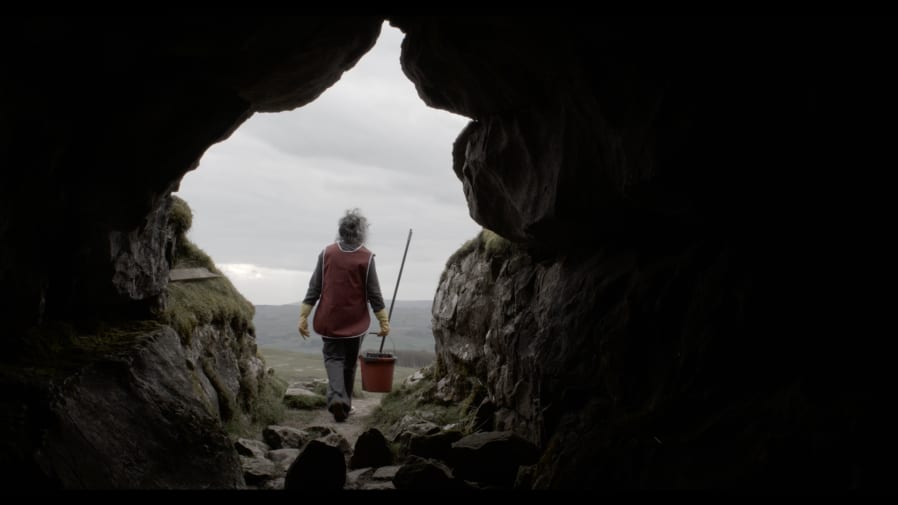A women stood at the mouth of a cave