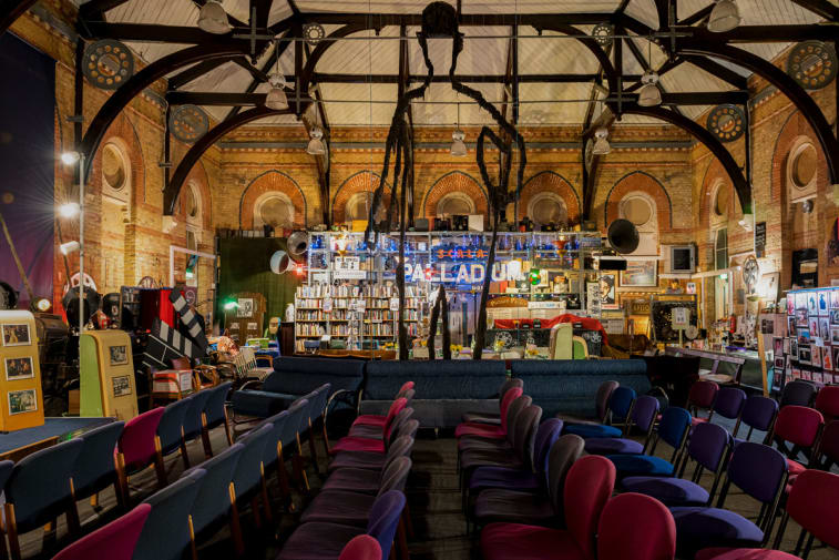Rows of seats in front of bare brick walls of The Cinema Museum