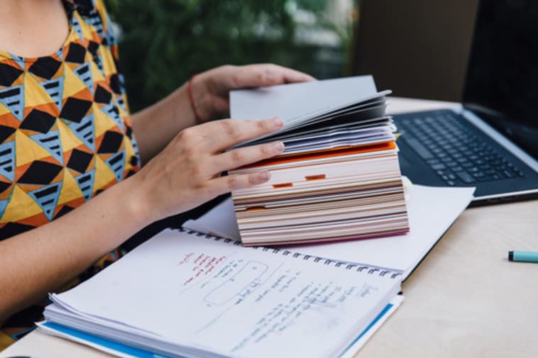 Hands hold a notebook and flip through the pages