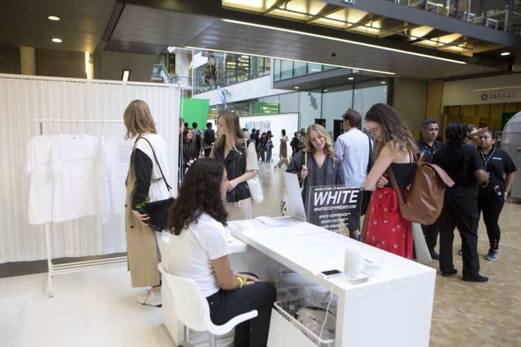 Woman sitting at all-white pop-up shop