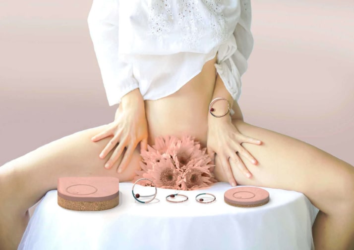 Figure of woman sitting on table surrounded by pink menstrual products (from Aneo by Ines Duplessis, MA Industrial Design)