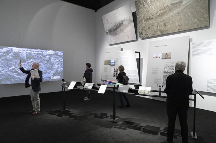 Photo of Maps of Defiance exhibition with visitors and panels. 
