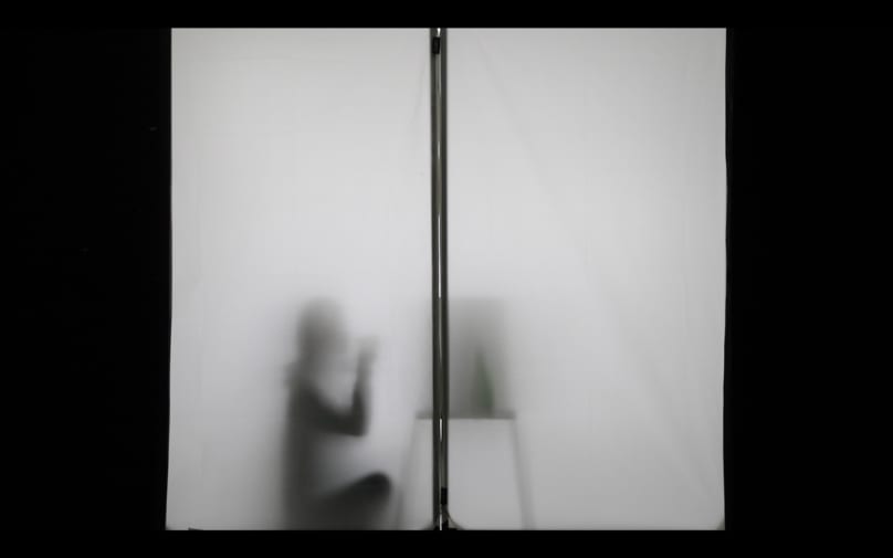 Silhouette of person sat at desk.