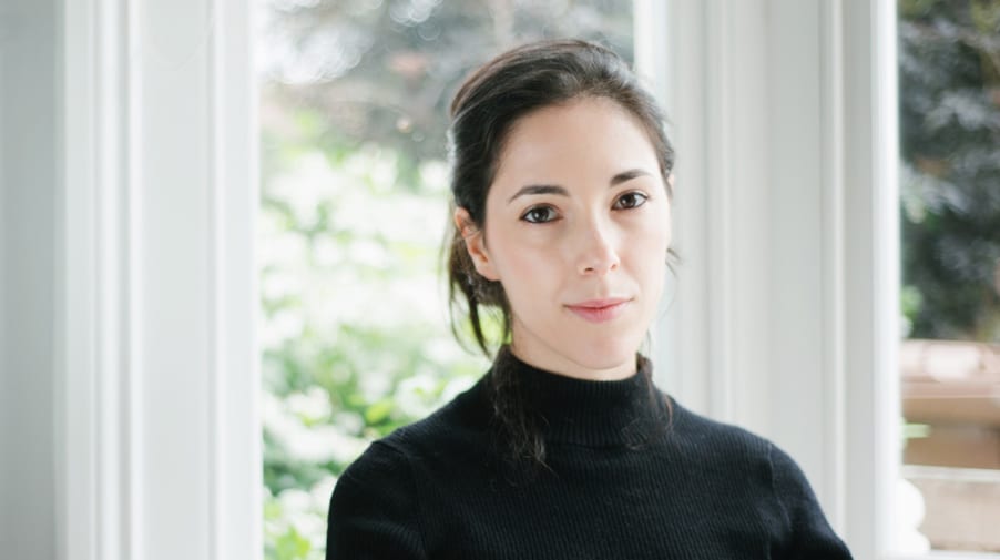 Portrait of Chiara, who has fair skin and black hair, wearing a black turtleneck