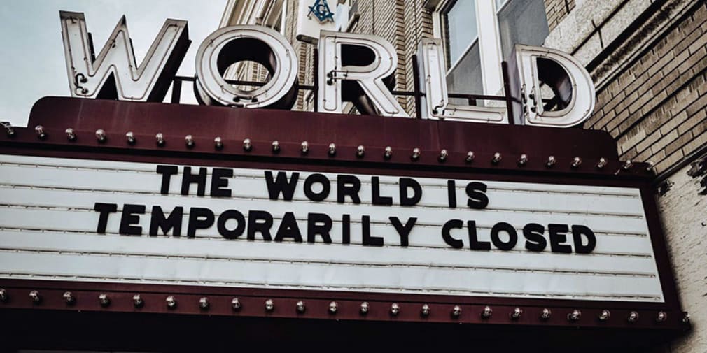 Image depicts a cinema board which reads: 'The world is temporarily closed.'