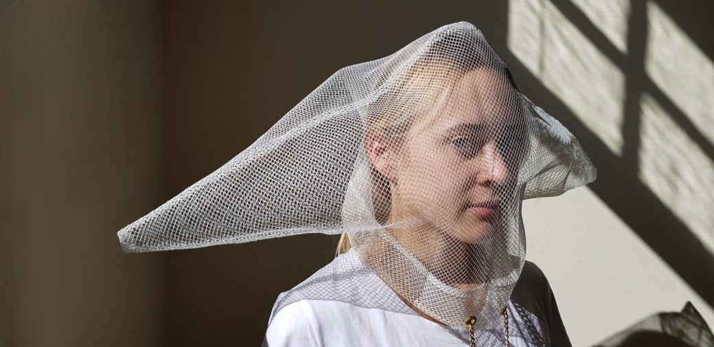 Woman wearing hood made out of mesh