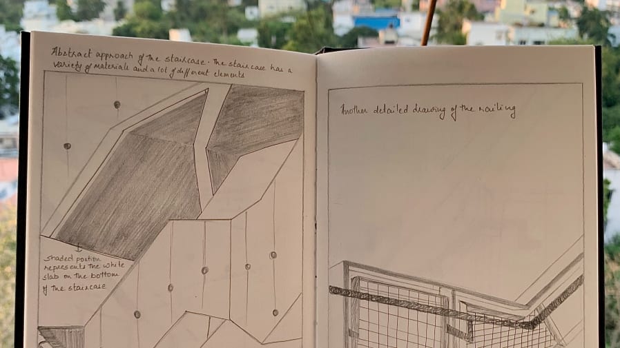 Pencil illustrations in a notebook held over a city skyline