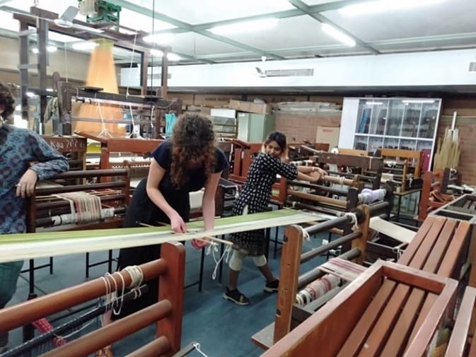 Students working with weaving equipment