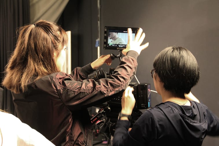 Students in TV studio, using camera