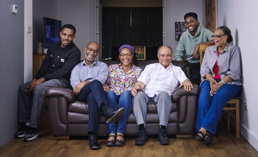 A photos of Jono and his family sat on a sofa smiling