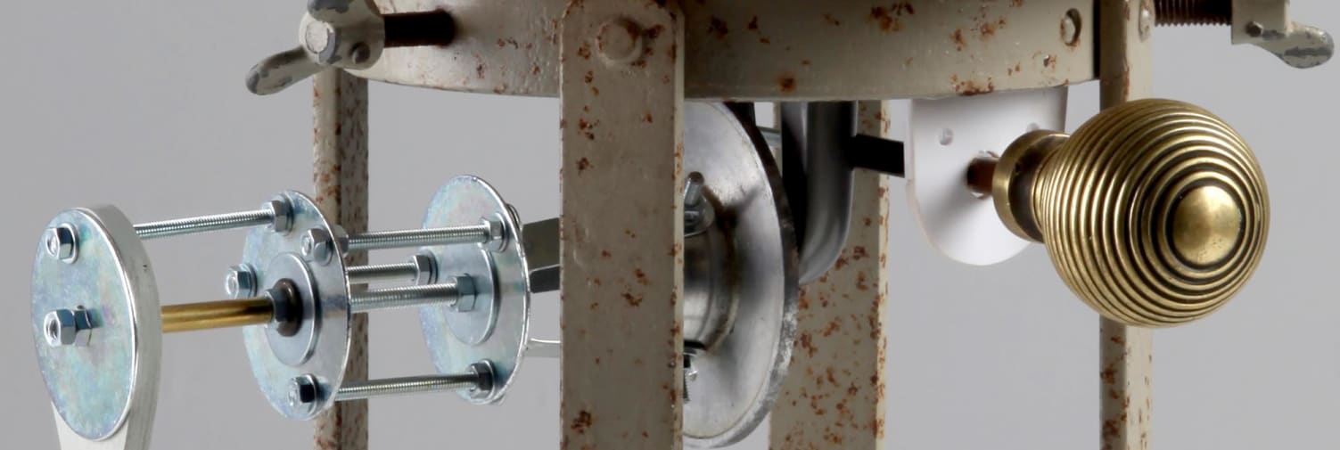 Close up of metal parts, screws and a doorknob.