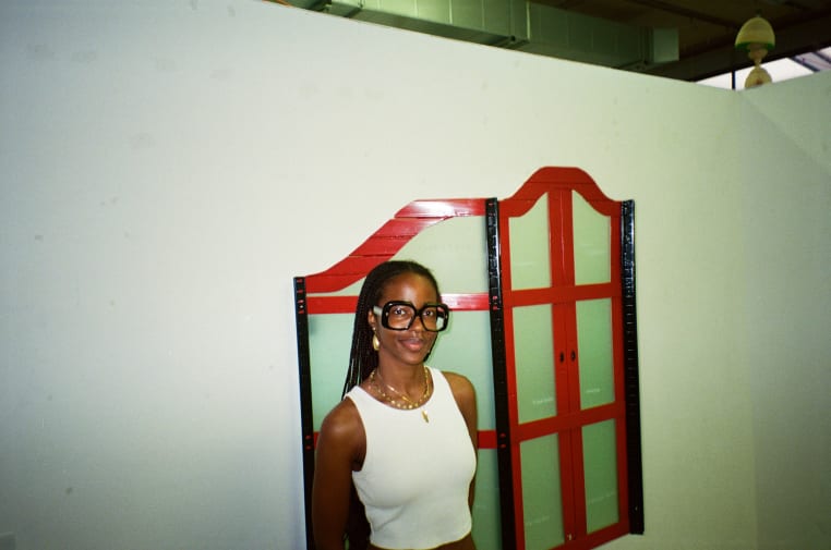 An image of a black woman in yellow tinted glasses