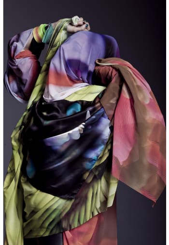 A figure is draped in scarves.