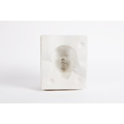 White plaster mould of a dolls face in negative