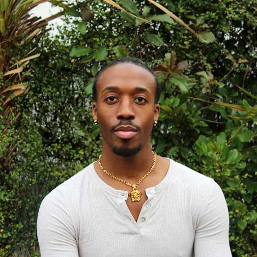 Individual wearing a white top with green background