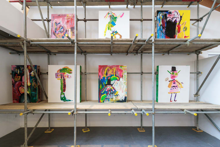 7 paintings displayed on scaffolding