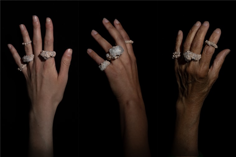 Three hands against a black background wearing 3 rings each.