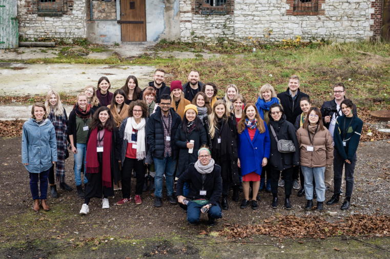 Group photo of students and academics in front of an old building